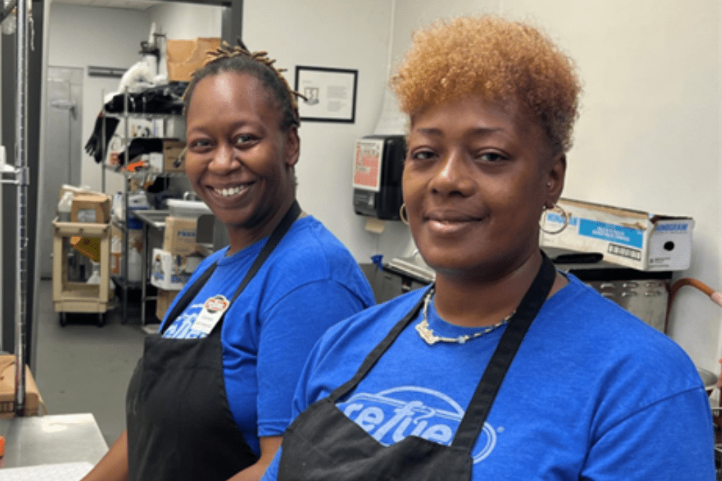 Two happy smiling Refuel team members with blue shirts.